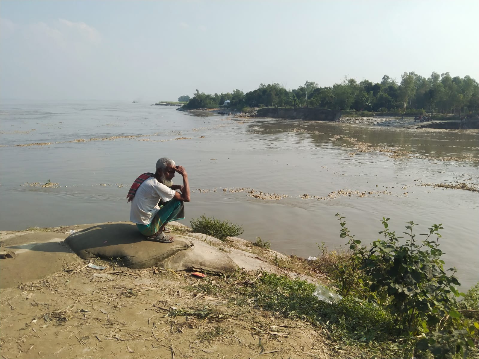Pach Thakuria, Sirajganj. Man witnessing the havoc caused by riverbank erosion. 2022 &copy; Savio Rousseau Rozario.