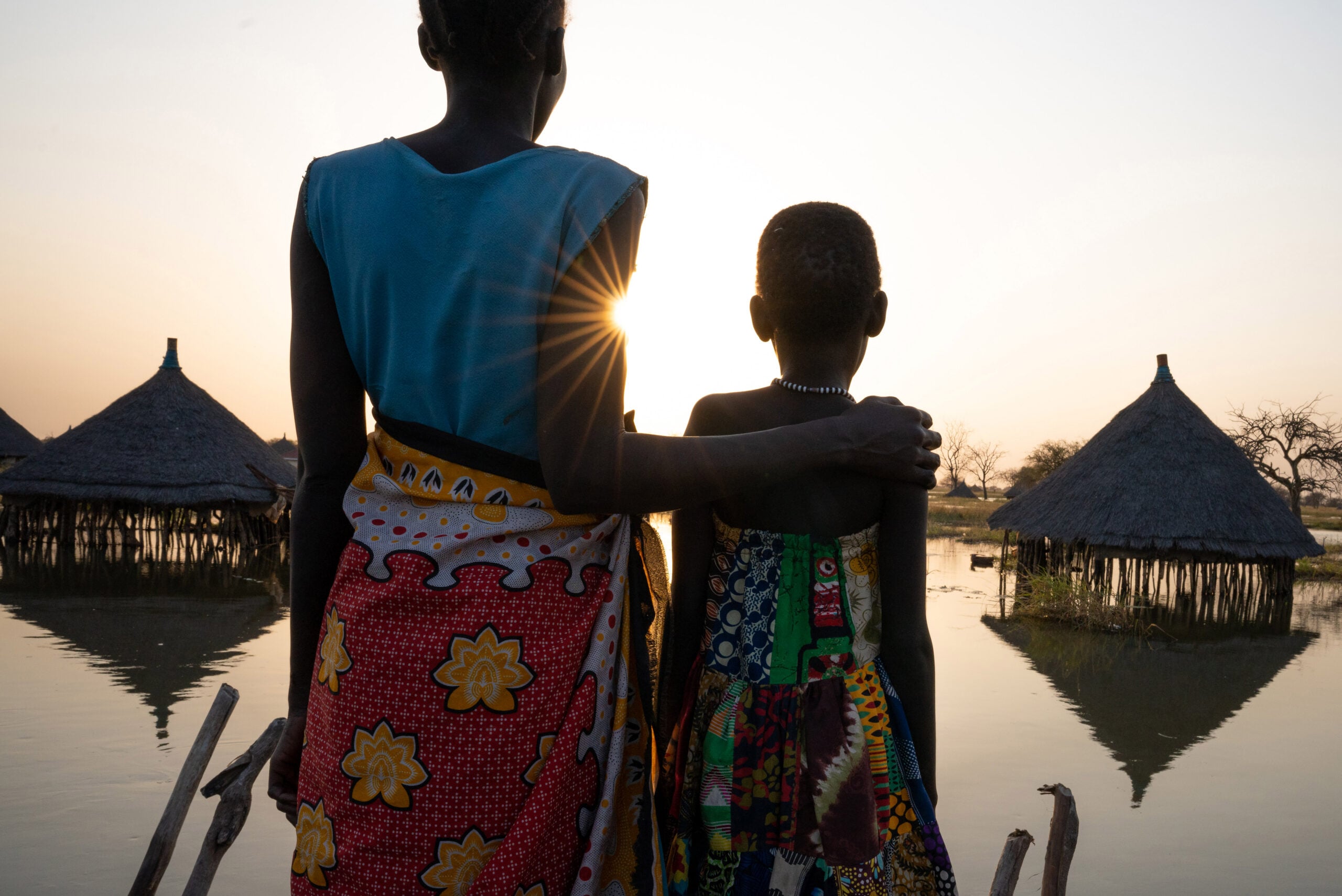 202201_Flooding_Twic East_Panyagor_Naftalin15 Jonglei State, South Sudan. A mother and daughter looking out at submerged houses. 2022 © UNICEF/UN0594299/Naftalin
